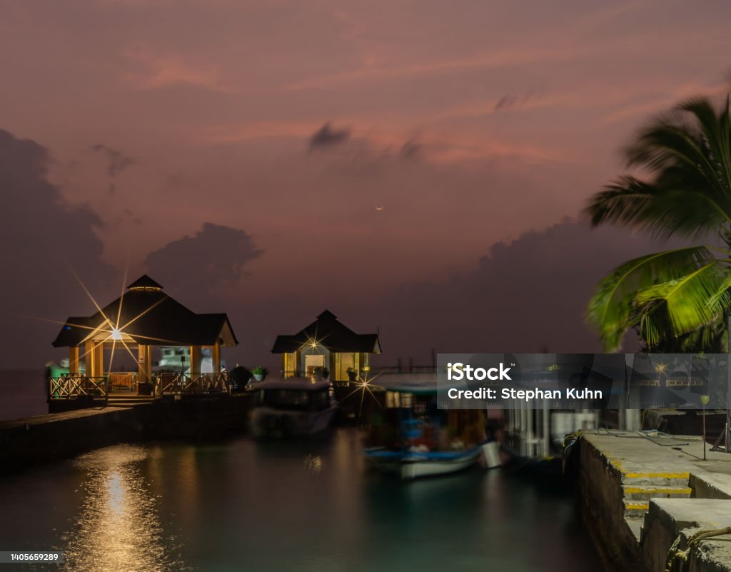 Dhoni Boats Dhoni Boats at pier at Maldivian Island after sunset Atoll Stock Photo