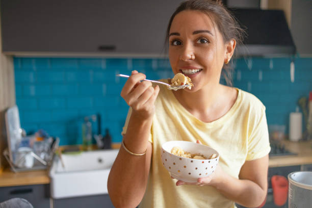 istock Young woman eating breakfast in the kitchen 1405659577