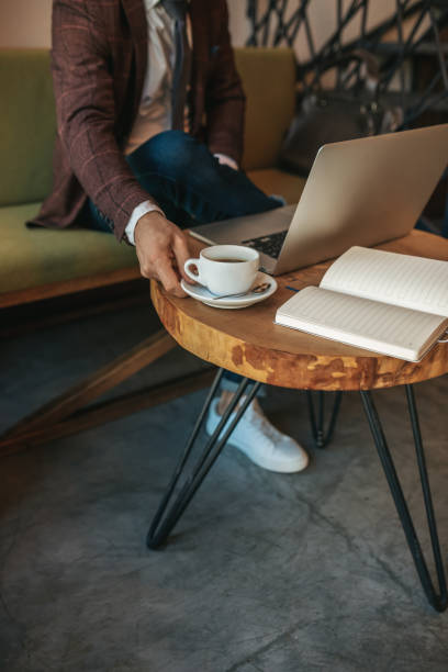 istock Male hand touching coffee on table near laptop 1405661110