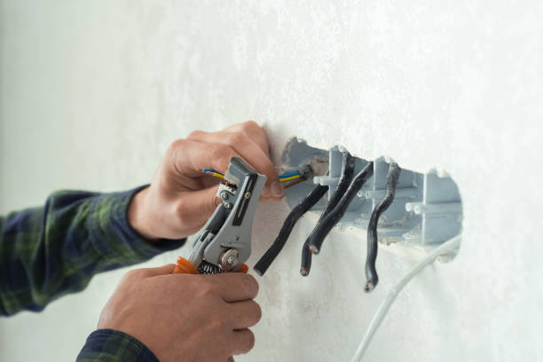 istock Electrician mounts a new socket on a white wall. Renovation process in a new apartment 1405662244