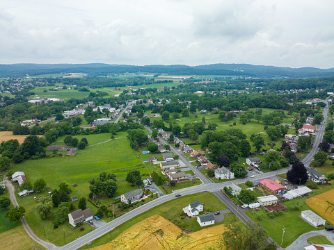 An aerial view of a small town surrounded by green forests and fields.