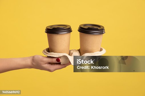 istock Profile side view closeup of woman hand holding and showing cup of hot takeaway mug drink in hand. 1405669692