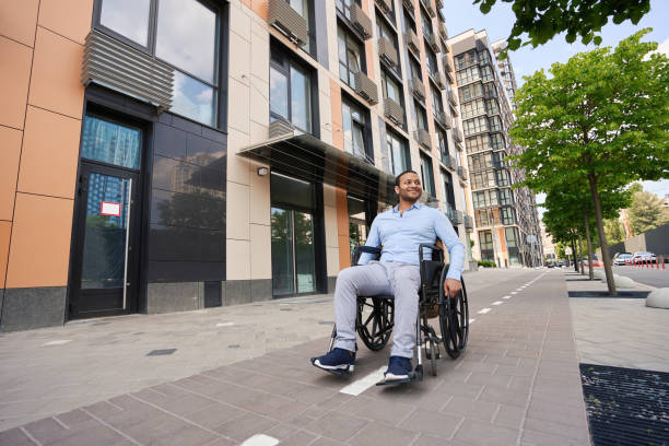 istock Young wheelchair-bound man looking around business district 1405671335