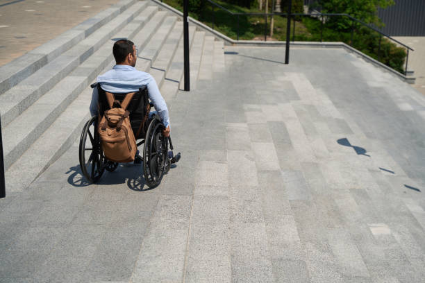 istock Man with disability descending concrete staircase outdoors 1405671379