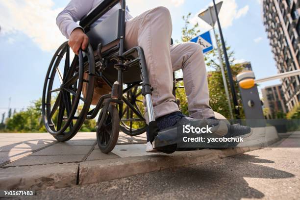 Disabled Man Going Down Curb In Manual Wheelchair Stock Photo - Download Image Now - Wheelchair, Curb, Disability