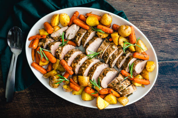 жареная свиная вырезка с картофелем и детской морковью - pork roast pork roasted meat стоковые фото и изображения