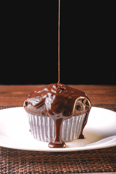 istock delicious chocolate flavor cupcake with homemade chocolate chips with extra liquid chocolate placed on a white plate excellent to be a dessert 1405675736
