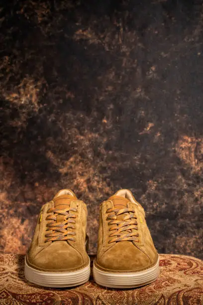 Photo of Detail of a pair of high-end brown casual sneakers with the background out of focus