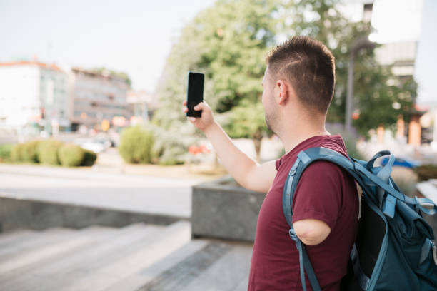 istock Young adult student using a smart phone outdoors 1405678049