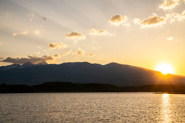 istock Sunset over the silhouette mountains and lake. 1405678114