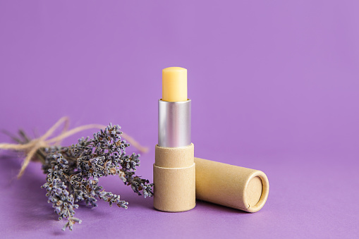 Natural kraft paper cosmetic tube. Mock up. Lavender Cosmetics. Open lip balm package on lavander violet background