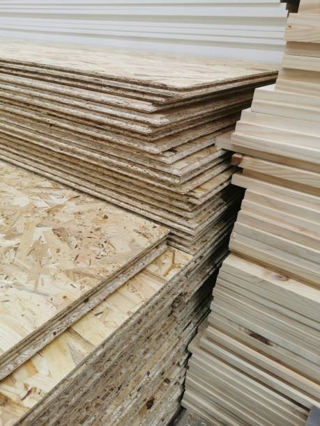 OSB sheets are stacked in a hardware store. The building material, wooden paneles OSB sheets are stacked in a hardware store. The building material with wood. pressboard stock pictures, royalty-free photos & images