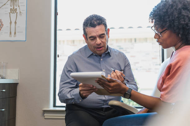 istock Patient and doctor look at paperwork outlining treatment options 1405683395