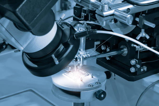 istock Chip testing equipment. Manufacturing of microchips. A close-up study of a test sample of a transistor chip under a microscope in the laboratory. Automation of production. 1405684788