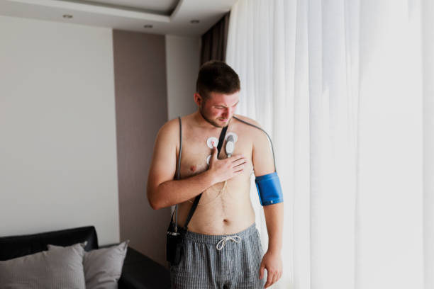 mann mit cardio-monitor, studium der arbeit des herzens, kardiologie. holter-monitor. medizinische diagnostik. gesundheitswesen, krankenhaus. ekg-sensoren - elektrokardiogramm und blutdruckmessung. - pulse trace arrhythmia electrode listening to heartbeat stock-fotos und bilder