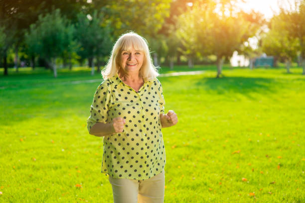 istock Senior woman standing and smiling. 1405687113