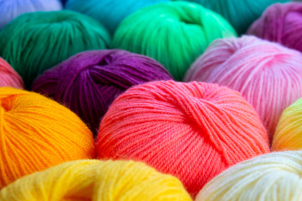 istock Bright multi-colored acrylic yarn. Colorful background. Low depth of field on skeins. 1405687248