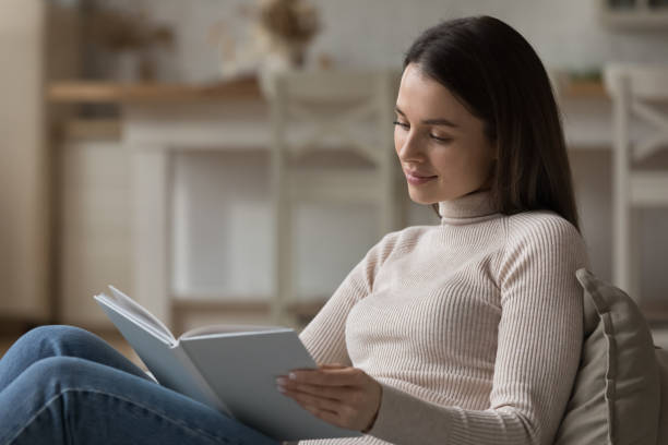 istock Positive student girl reading textbook, preparing for report at class 1405688430