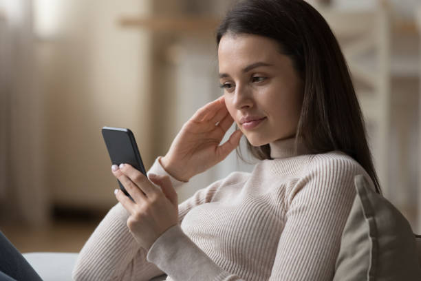 istock Beautiful young smartphone user woman reading text message 1405688434