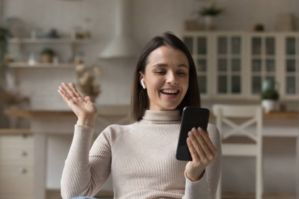 istock Happy girl with wireless earphone talking on video call, 1405689249