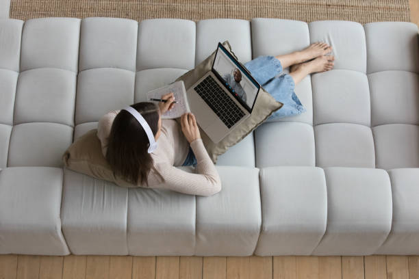 istock Young student girl in wireless headphones watching learning webinar 1405689947
