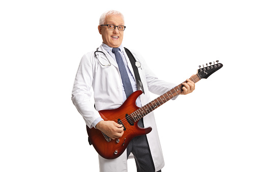 Male doctor playing an electric guitar isolated on white background