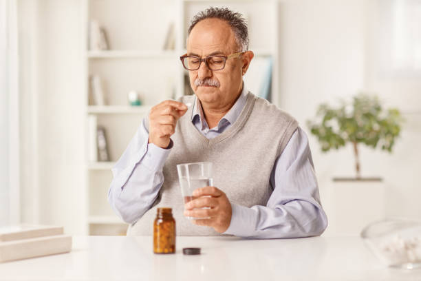 istock Mature man taking medications and sitting at a table 1405690734