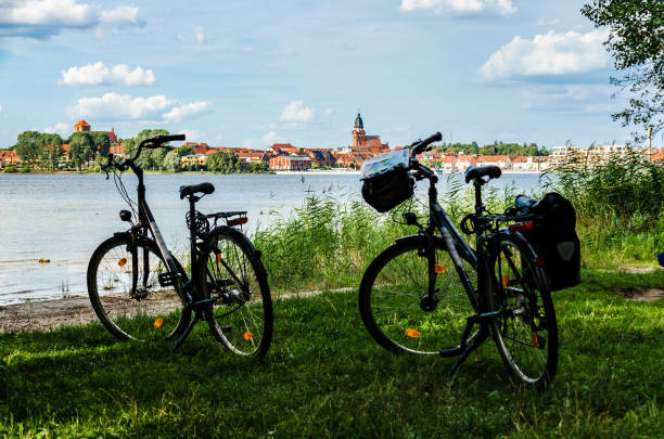 Cycling at the Müritz Mecklenburg Lake District Two bicycles stand on an idyllic bank of the Müritz in summer, in the background the town of Waren an der Müritz. muritz national park photos stock pictures, royalty-free photos & images