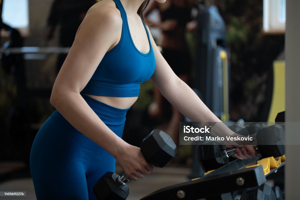Close up of woman's hand holding dumbbell in gym. stock photo Close up of woman's hand holding dumbbell in gym. Bicep Stock Photo