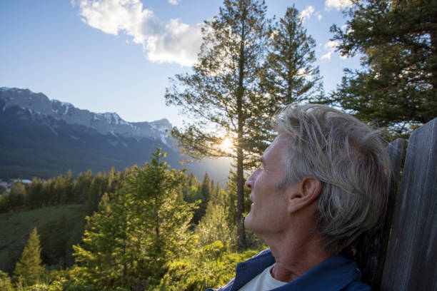 istock Man relaxes in lounge chair, at mountain viewpoint 1405693374
