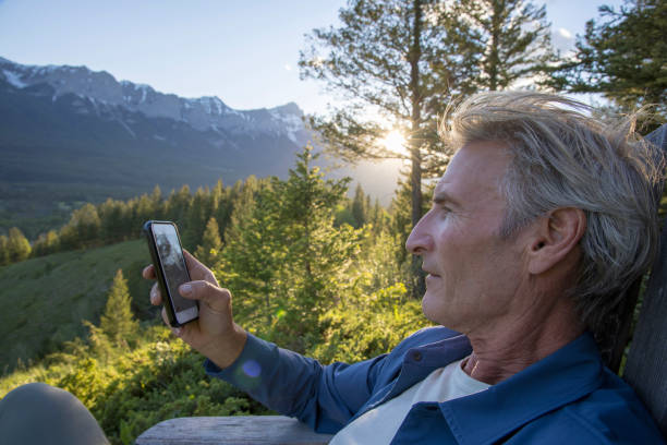 istock Man relaxes in lounge chair, at mountain viewpoint 1405693409