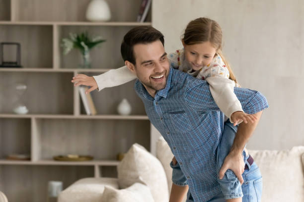 istock Happy father holding on back cute daughter. 1405695766
