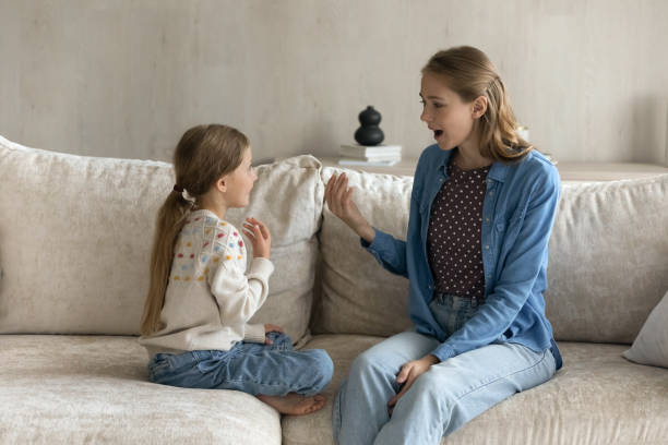 istock Happy little kid girl learning pronouncing sounds with caring mum. 1405695802
