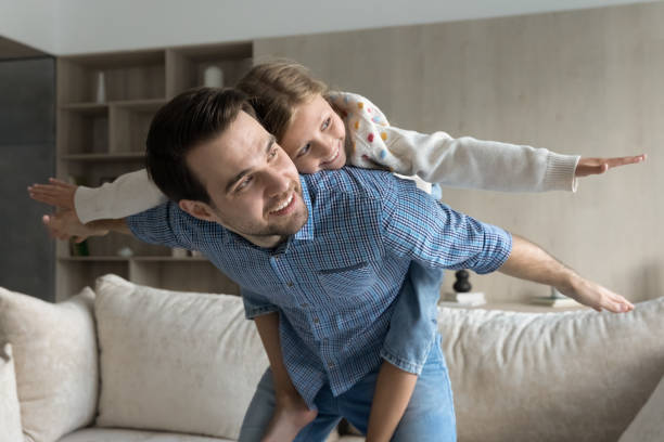 istock Happy young father holding on back joyful small child. 1405695809