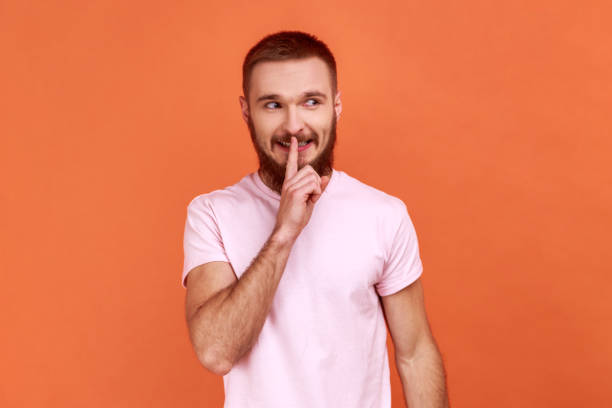 istock Man showing hush with finger on his lips gesture, shushing, asking to keep silence. 1405695955