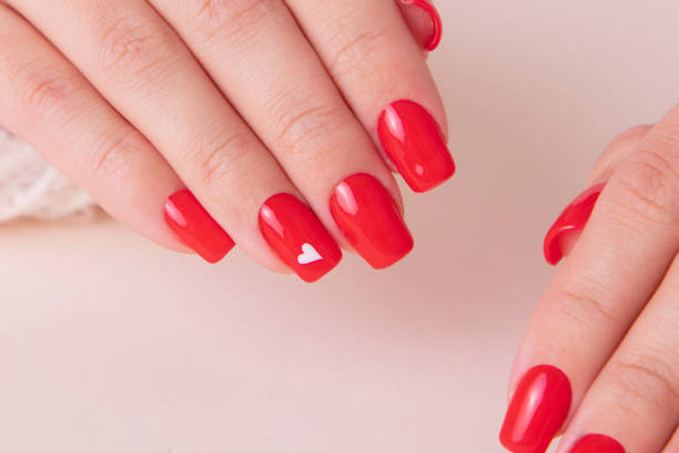 istock Female hands with red manicure nails, hearts design 1405699290