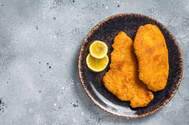 istock Roasted breaded german weiner schnitzel on a plate. Gray background. Top view. Copy space 1405701334