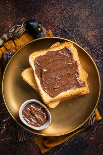 istock Stack of Toasts with chocolate Hazelnut cream in plate. Dark background. Top view 1405701959