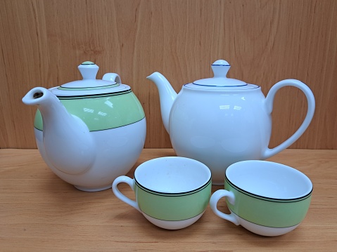 Tea pot, 2 tea cups and kettle on the kitchen counter