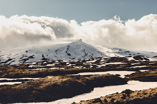 Panorama of Snæfellsjökull Glacier Mountain Range, Snowcapped Stratovolcano - Snaefellsjokull Mountain Peak under sunny summer skyscape. Snæfellsjökull Volcano, Western part of the Snæfellsnes - Snaefellsness Peninsula, Iceland, Nordic Countries, Northern Europe, Europe.