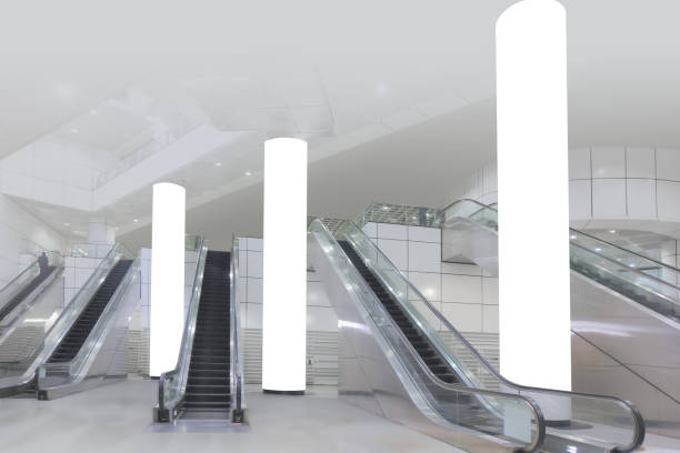 istock Blank white pillars for pillar wrap billboard advertising mockup template. Extreme narrow vertical banners near escalators. 1405720513