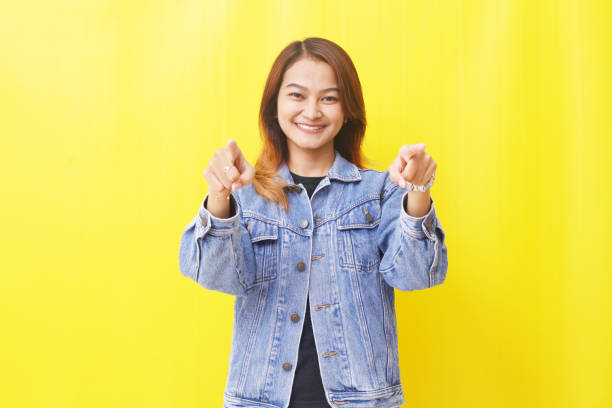 istock happy asian woman pointing empty space 1405725415