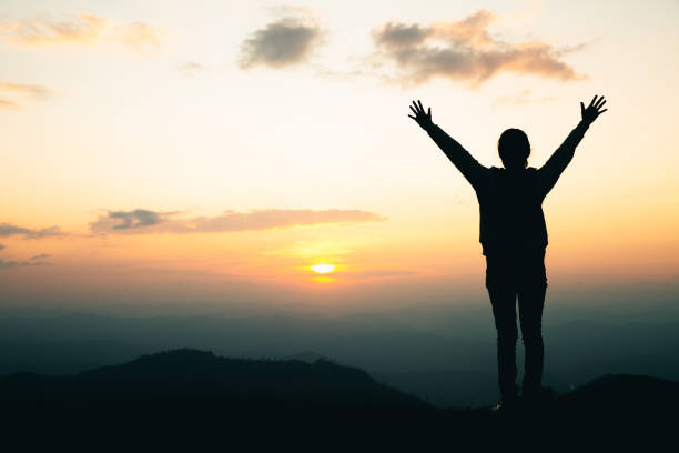 silhouette d’une femme priant sur la montagne, priant les mains avec foi en religion et croyance en dieu. - surmonter les difficultés photos et images de collection