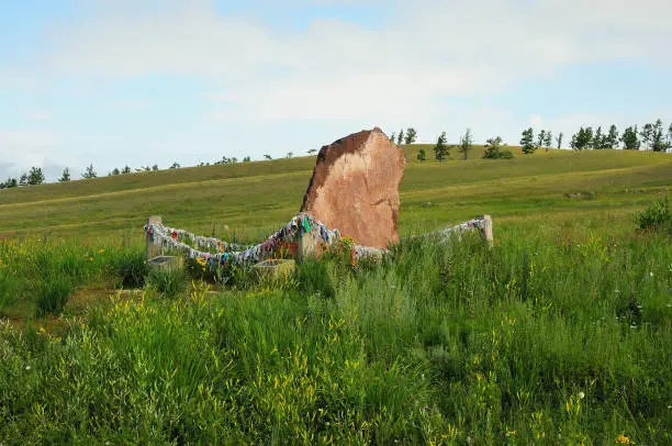 Photo of Ritual hitching post with a horde of colorful ribbons on a hillside. Khakassia, Siberia, Russia.