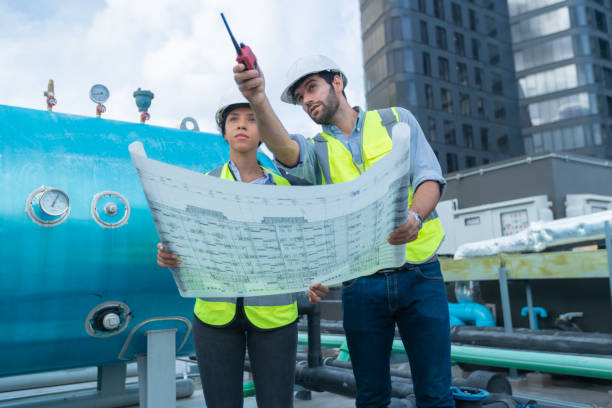 istock Engineer under checking the industry chilled water fan coil unit air conditioner is water cooling tower air chiller HVAC system of large industrial building to control air system 1405727969
