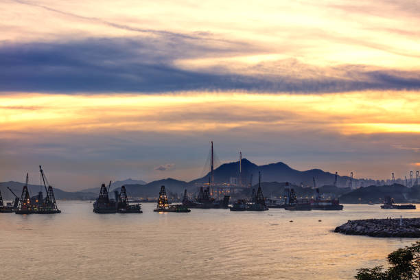 istock Sunset over crane boats, ferries and Stonecutters Bridge 1405729090
