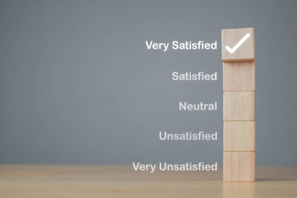 Evaluation and satisfaction concept. On wood blocks, a correct mark shows very satisfied customers. Copy space on grey background.