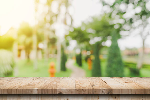 istock Empty wooden table top and Abstract blurred light bokeh and blur background of garden trees in sunlight. product display template with copy space. 1405730675