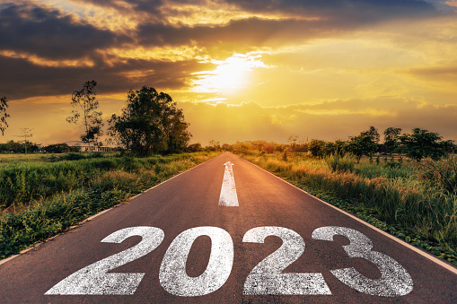 Empty asphalt road and New year 2023 concept. Driving on an empty road to Goals 2023 with sunset.