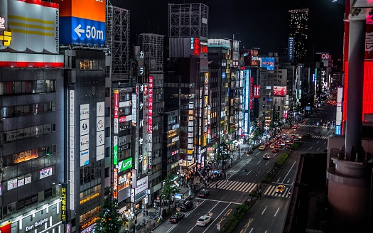 Neon lights and illuminated billboards of Shinjuku glittering at night in the heart of Tokyo, Japan’s vibrant capital city.